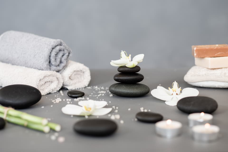 Spa stones, towels and candles in a calm treatment setting